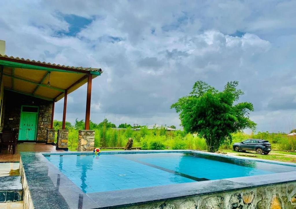 a swimming pool in front of a house at The WildRocks Jawai in Nāna
