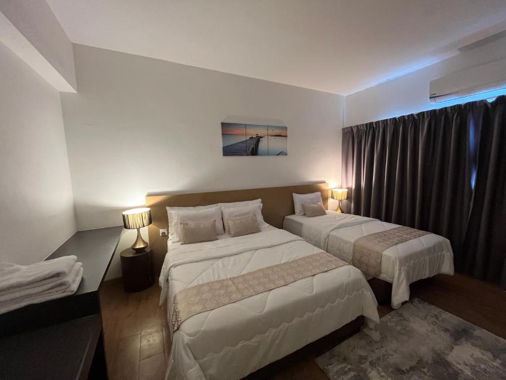 a hotel room with two beds and a window at Putra Hotel at Mydin Tunjong in Kota Bharu