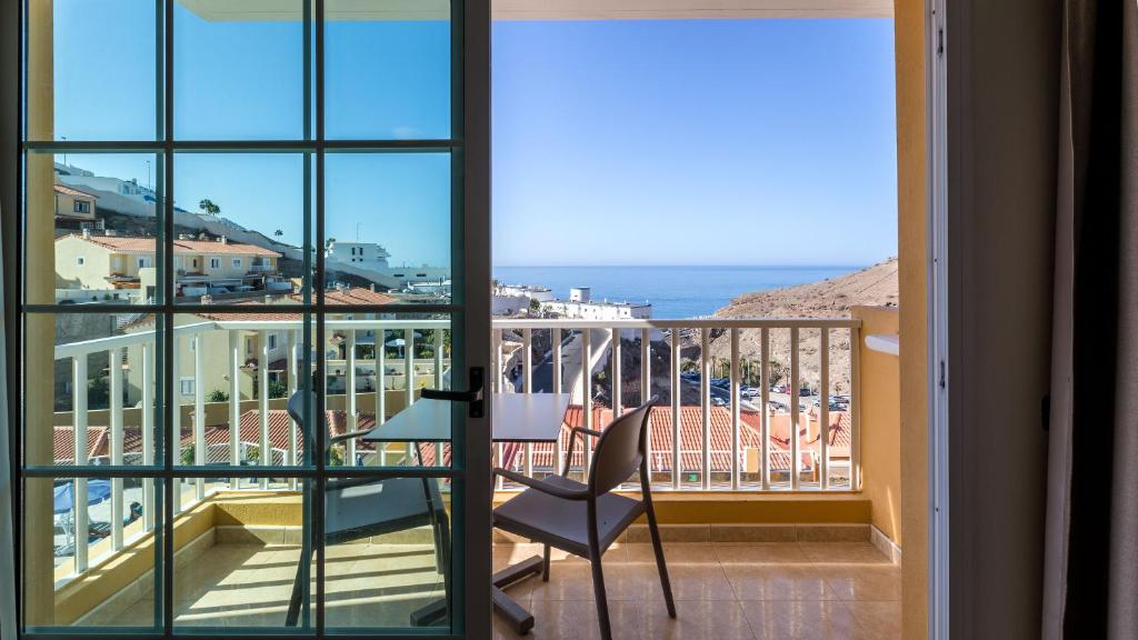 a balcony with a chair and a view of the ocean at Villa del Mar in Patalavaca