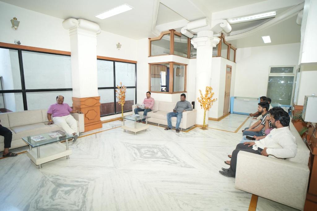 a group of people sitting in a room at HOTEL ABHISHEK, Shirdi in Shirdi