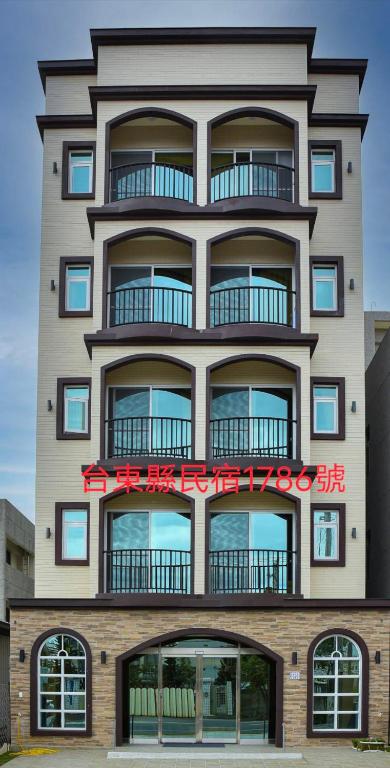 a tall building with a red sign on it at 欣京棧民宿 in Taitung City