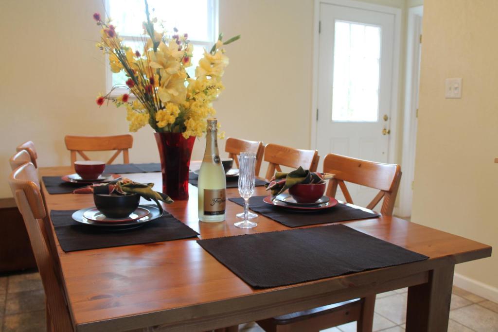 a dining room table with a bottle of wine and flowers at Pipestem Spa, Event Center and Mountain Chalets in Pipestem