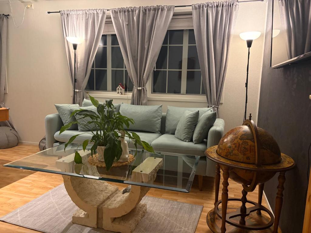 a living room with a couch and a glass table at JOlster apartaments - lake view in Årdal