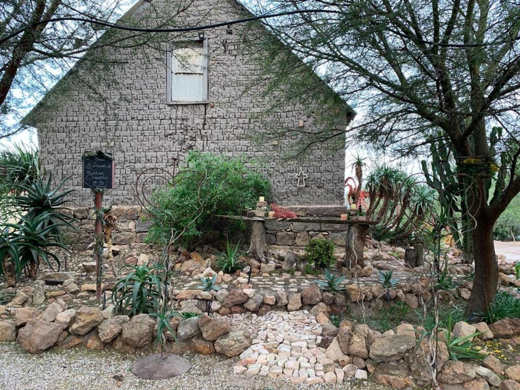 a stone house with a garden in front of it at Vensterklip Guest Farm in Elands Bay