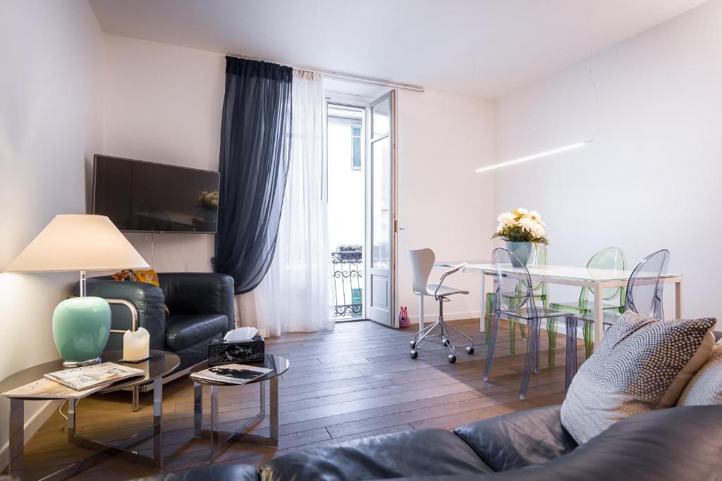 ein Wohnzimmer mit einem Sofa und einem Tisch in der Unterkunft Como Design Apartment - byMyHomeinComo in Como