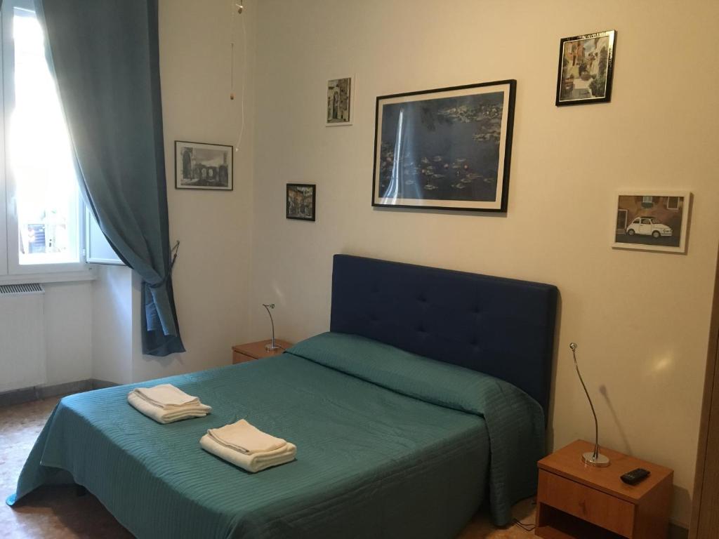 een slaapkamer met een blauw bed met 2 handdoeken erop bij Delightful apartment 100 meters from the Colosseum in Rome