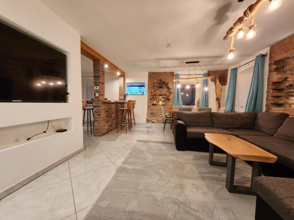 a living room with a couch and a tv at Bachhaus Marktredwitz Haupthaus in Marktredwitz