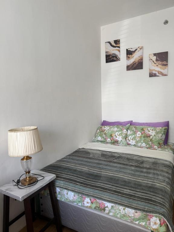 a bed in a room with a lamp on a table at Bella's Flats in Bayanihan in Pajak
