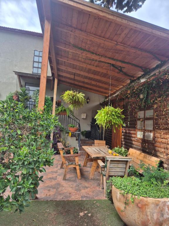 eine Terrasse mit einem Holztisch und Bänken in der Unterkunft hotel vital in Rechovot