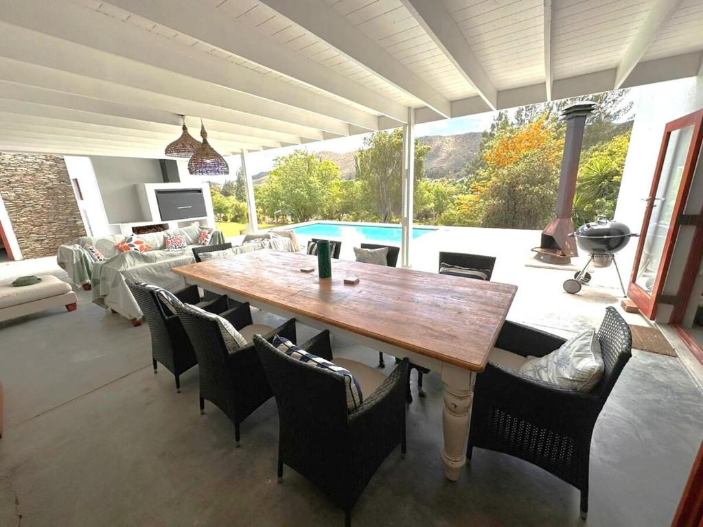 a dining room with a table and chairs and a pool at Barrydale Bliss in Barrydale