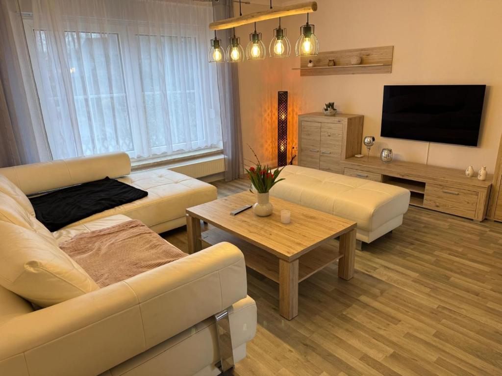 a living room with a couch and a tv at Ferienhaus in Glauchau, Garten, Grillmöglichkeit, Privatparkplatz, Kaffeevollautomat, Wlan, Netflix in Glauchau