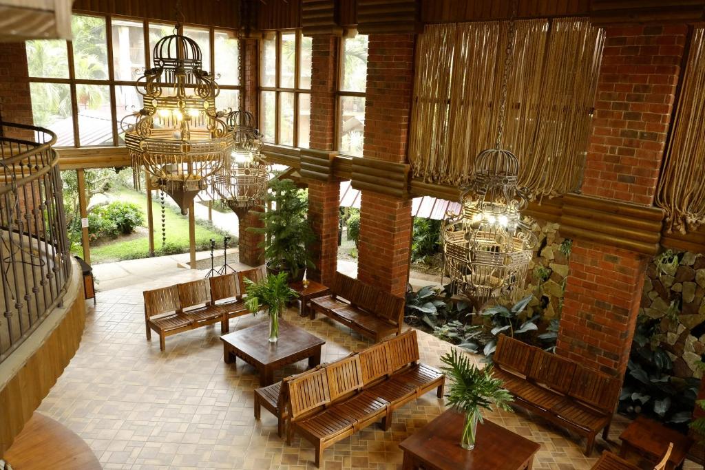 Habitación grande con bancos y lámparas de araña. en Hotel Gran Jimenoa, en Jarabacoa