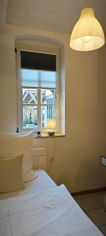 a bedroom with a white bed and a window at Hostel am Burgenring - kostenloser Parkplatz, Zentrum, Self Check-In, Küche in Schlitz