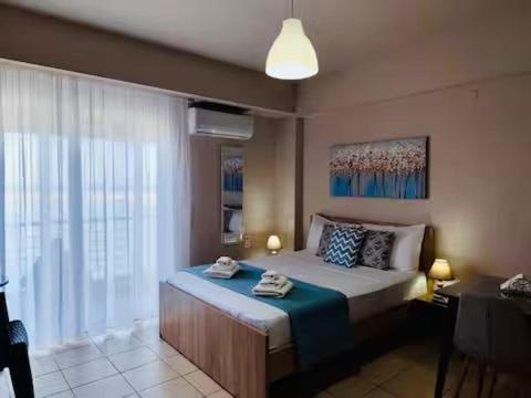 ein Schlafzimmer mit einem Bett und einem großen Fenster in der Unterkunft Marirena Seaside 1 in Kokkinos Pyrgos
