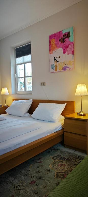 a bedroom with two beds and a painting on the wall at Pension Burgenring in Schlitz