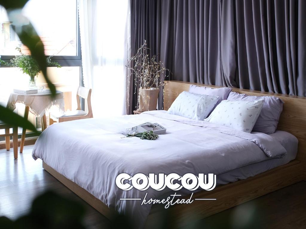 a bed with white sheets and pillows in a room at CouCou Homestead II - Mini Hotel District 1 in Ho Chi Minh City