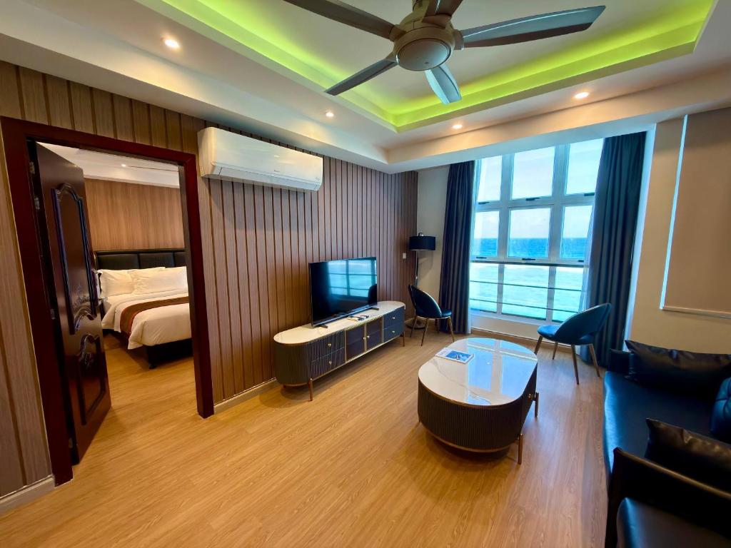 a hotel room with a bedroom with a bed and a television at Rivethi Beach in Hulhumale