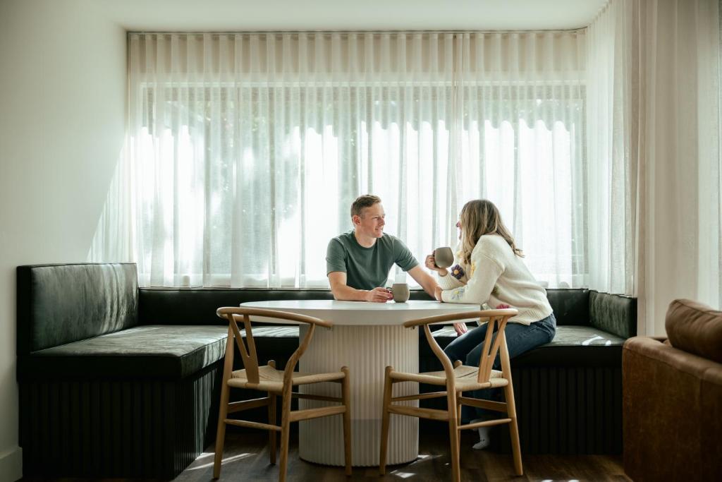 a man and woman sitting at a table with a baby at Apartment Two - Apartments on Gavan in Bright