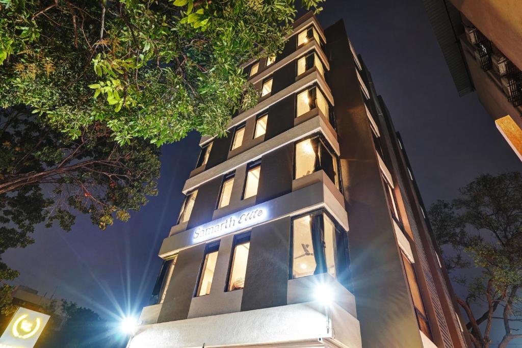 a tall building with its lights on at night at Hotel Samarth Elite Baner - Indian Guests Only in Pune