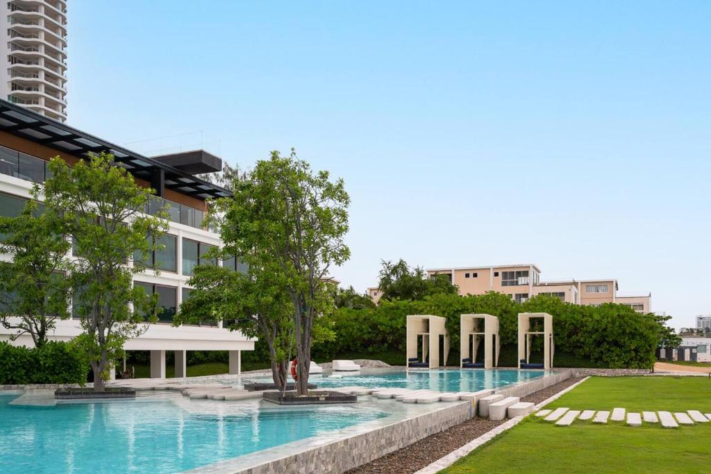 a large swimming pool in front of a building at HighFloor Seaview Condo,Pool by the beach,Kitchen,Gym,WIFI in Jomtien Beach