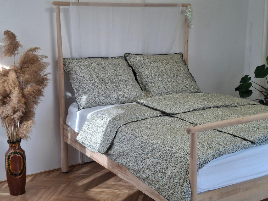 a bed with a wooden frame in a room at Villa Hortensia in Aszófő