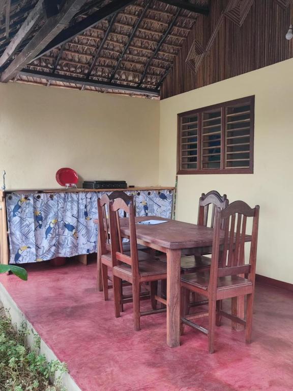 a wooden table and chairs in a room at Chez Rosa in Nosy Be