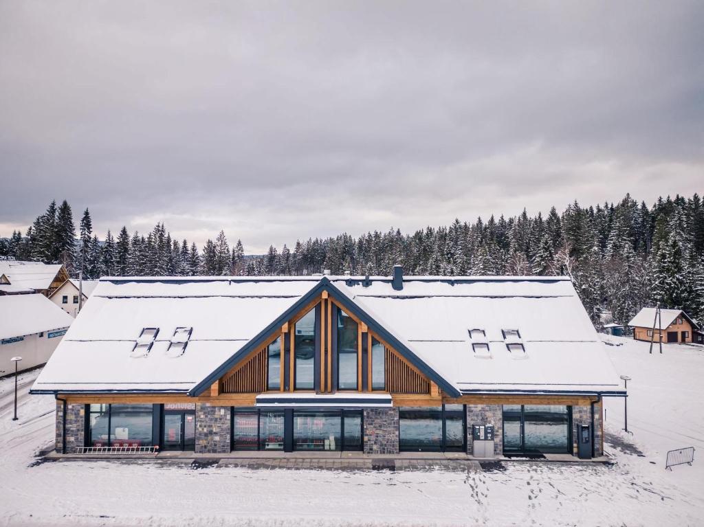 a wooden house with snow on the roof at Ski and Bike Residence in Istebna