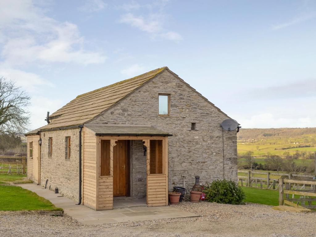 a small stone building with a large door at Brandy's Barn in Middleham