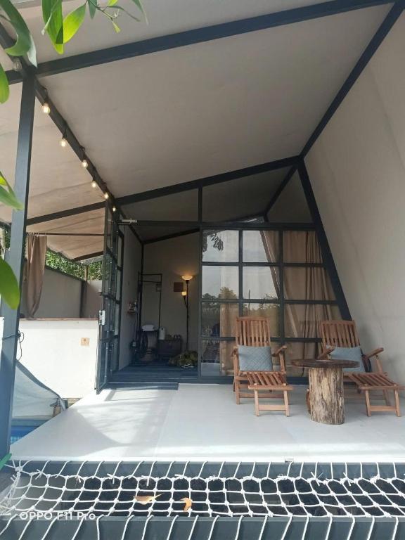 a screened in porch with two chairs and a table at Homestay in Nhơn Trạch