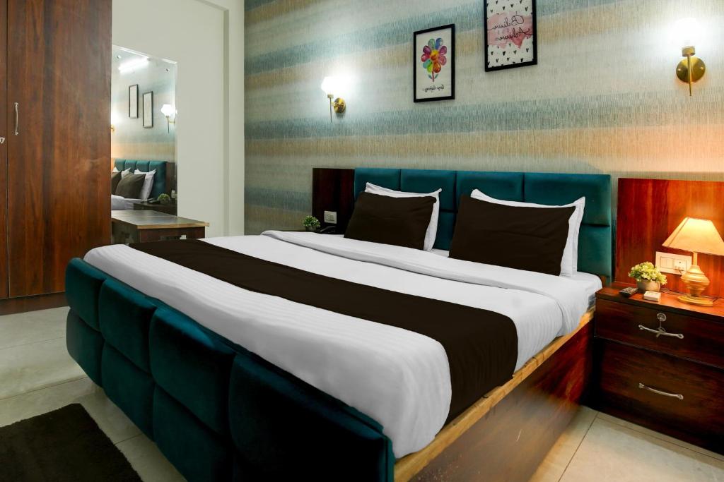 a large bed with a blue headboard in a room at Hotel O Riddhinn6 in Jalandhar