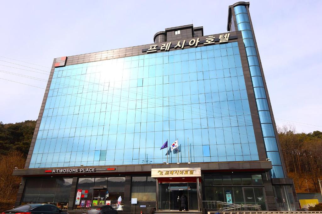 a large glass building with a sign on it at Incheon Freshia Hotel in Incheon