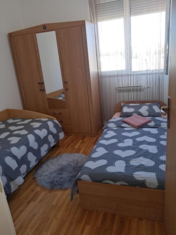 a bedroom with two beds and a mirror at Apartman Antonio in Gospić