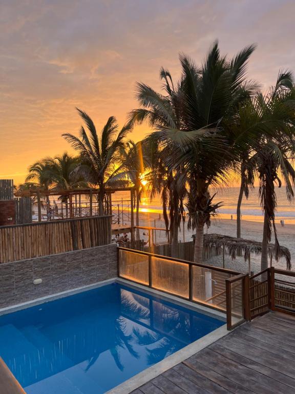 a pool with a view of the beach and palm trees at Villa Vichayito Relax in Vichayito
