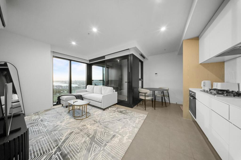 a kitchen and living room with a couch and a table at River View 1BR Docklands Apartment sleeps 3 in Melbourne