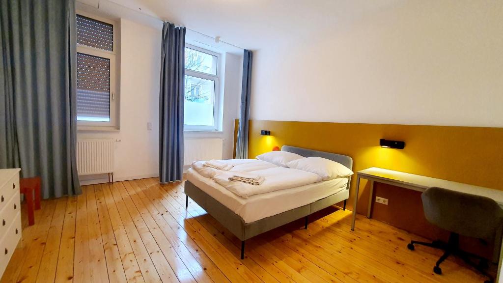 a bedroom with a bed and a desk and a window at Zimmer im Erdgeschoss II in Mannheim