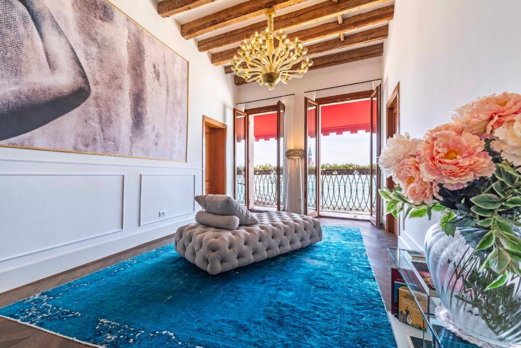 a living room with a blue rug and a chandelier at Porta da mar in Venice
