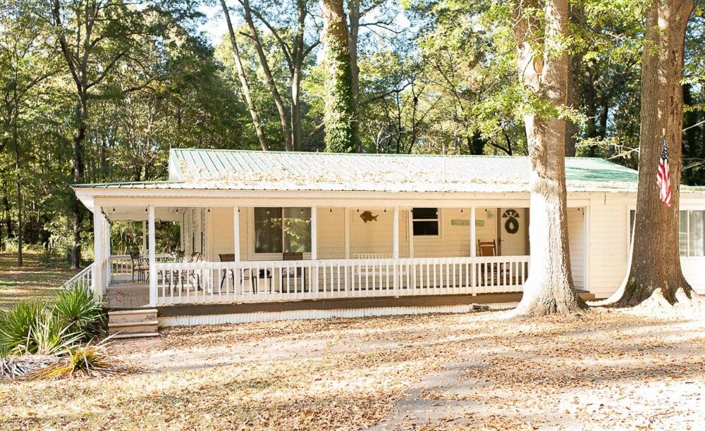 a white house with a porch and a tree at The Tackle Box in Guntersville