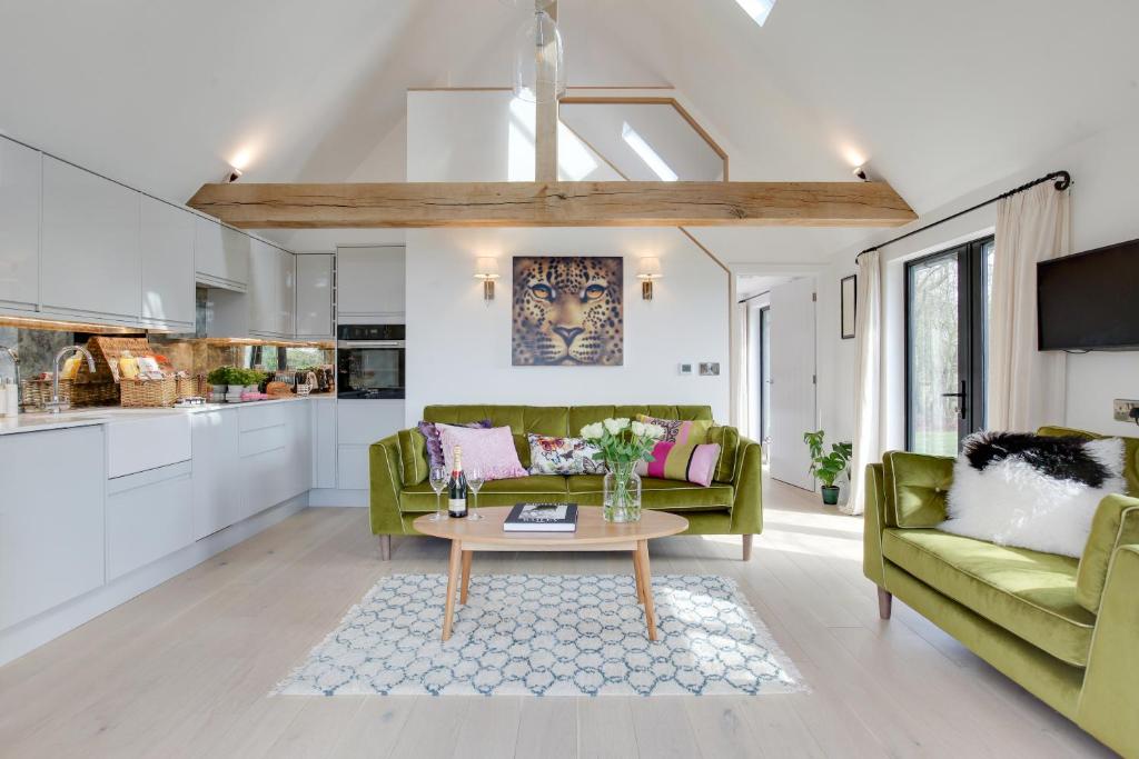 a living room with a green couch and a table at Little Larks Barn in Felsted Station