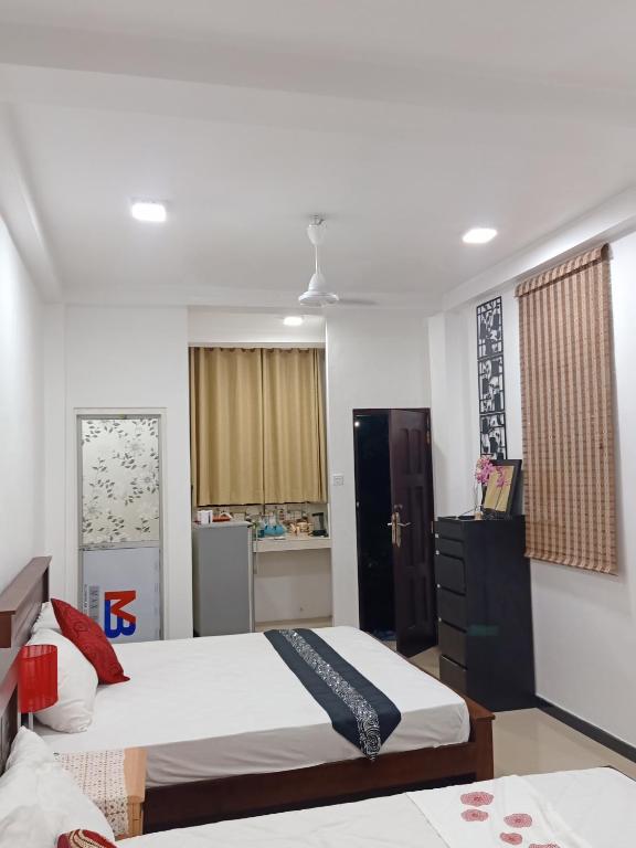 a bedroom with two beds and a kitchen at Rian Rest in Dehiwala
