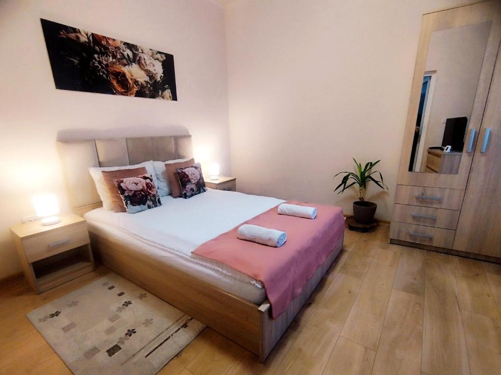 a bedroom with a bed with two towels on it at Apartament Andreas - centru, confort si relaxare in Arad