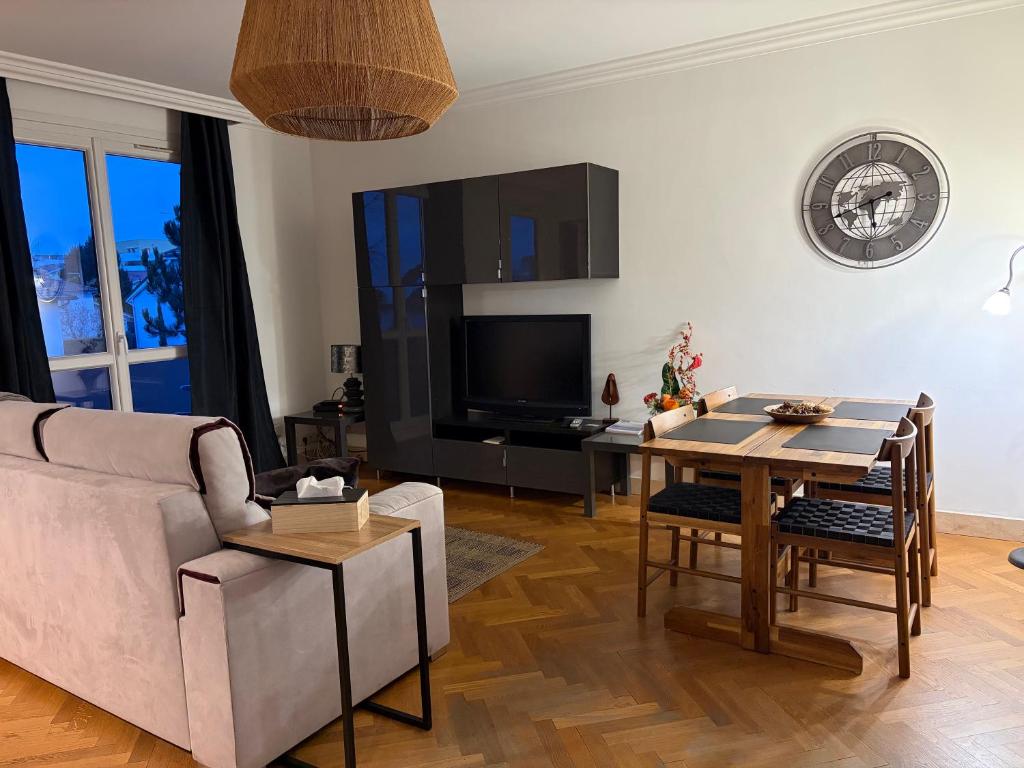 a living room with a couch and a table at Le Relais des Cyclamens Bron in Bron