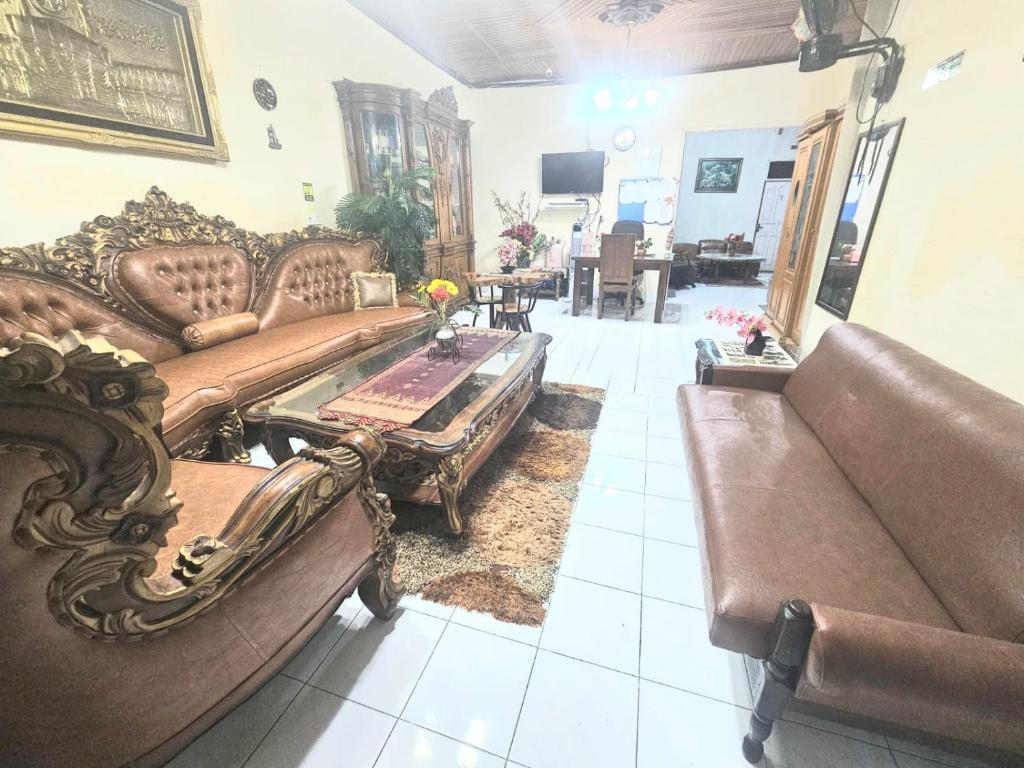 a living room with a couch and a coffee table at Penginapan Bunga Sonsang Padang Syariah in Tabing