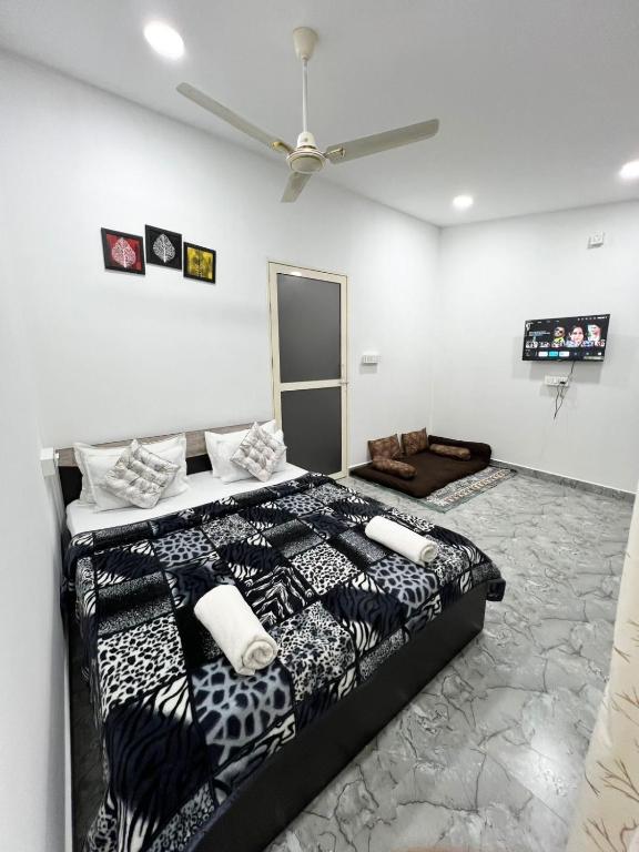 a bedroom with a black and white bed and a ceiling at Eva Beach Side Room in Mandrem