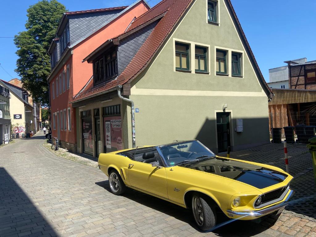 a yellow car parked on a street next to a building at Ferienwohnung Zwätzi in Jena
