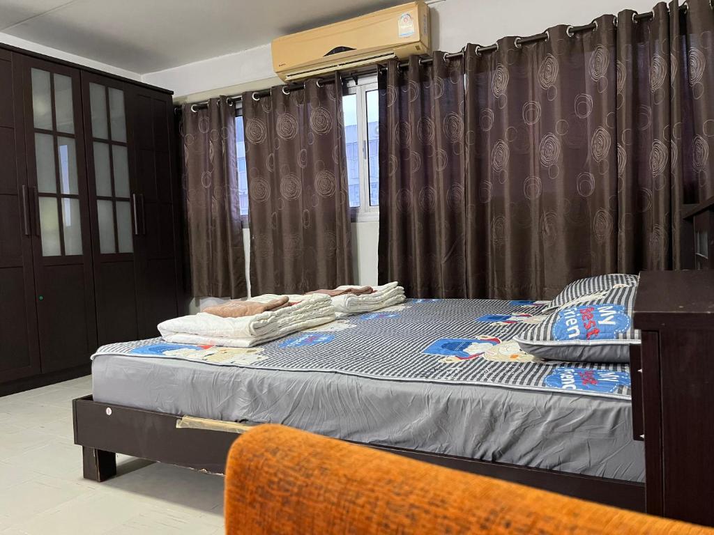 a bedroom with a bed and a window with curtains at Impact Arena C5 by Jintana in Thung Si Kan