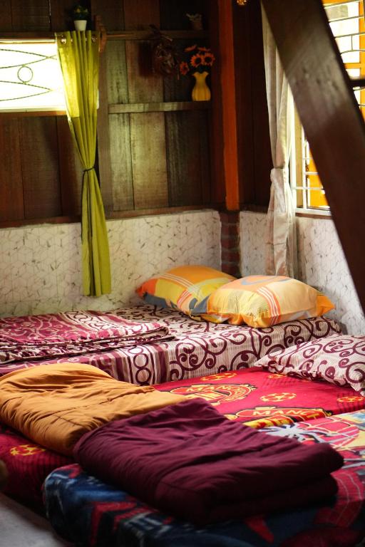 two beds sitting next to each other in a room at Swindo Homestay 77, Small House in Berastagi