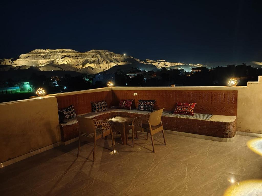 a table and chairs on a balcony at night at Nefertari Palace apartments in Al Aqālitah