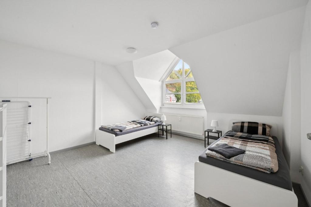 a white room with two beds and a window at Worker Place Lennestadt in Lennestadt