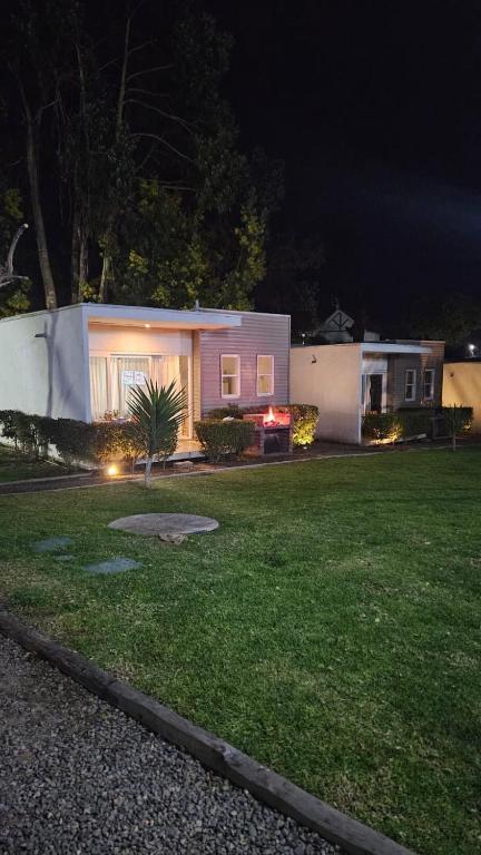 a house in a yard at night at De Peppino Cabañas in Papudo