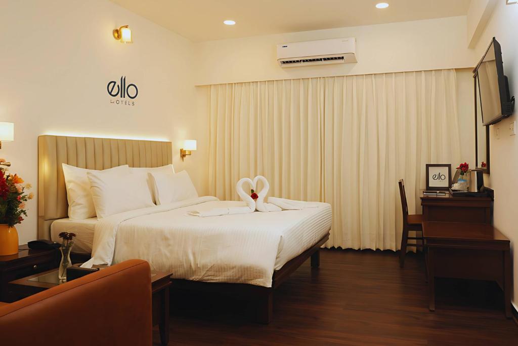 a hotel room with a bed with a bow on it at Ello Hotels in Bangalore